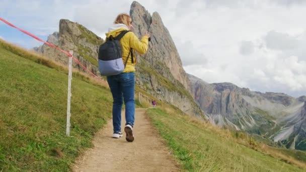 배낭을 금발의 여자는 카메라로 사진을 찍는다 이탈리아의 알프스 산맥에서 관광객들은 — 비디오