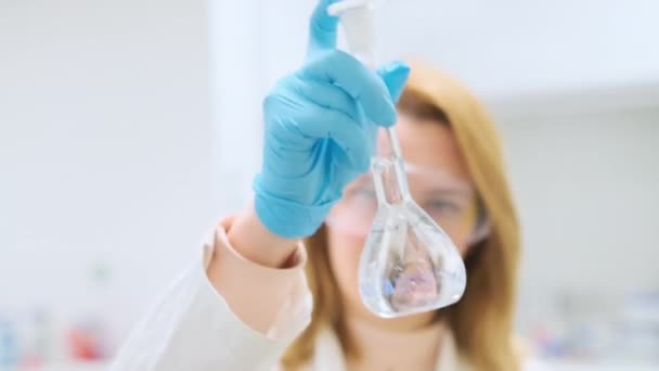 보호용 고글을 과학자가 플라스크를 흔들고 장갑을 실험실 연구를 액체를 — 비디오