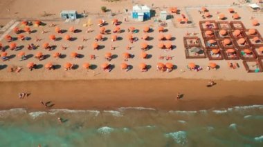 Venedik yakınlarındaki kumsalda turuncu şemsiyeler ve güneş panzeleri. Adriyatik kıyıları güneşli yaz günlerinde hava manzaralı turistler için hazır