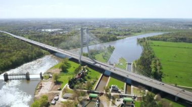 Redzinski Köprüsü, Wroclaw 'da akan barajın yanında parlayan suyla uzun Oder nehrinin üzerine inşa edildi. Araçlar kablo destekli pilon köprü hava görüntüsüyle gidiyor.
