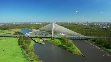 Oder nehrinde Redzinski Köprüsü üzerine kablo ile inşa edilmiş küçük yeşil bir ada. Wroclaw 'dan Pylon Köprüsü ve yemyeşil gökyüzü manzarasının altında