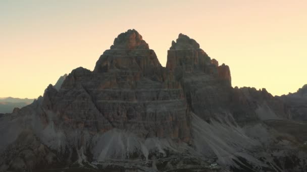 雄大なラバレドの3つのピークは アルプスの砂で覆われた丘陵地帯を伴う山岳地帯を支配し 日の出の素晴らしいバックライト付きの空中ビューで — ストック動画
