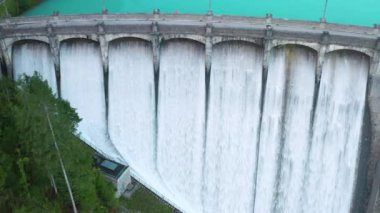 Santa Caterina Barajı 'nın havadan görünüşü, gölün üzerine inşa edilmiş büyük bir mimari yapı, güçlü su akıntılarıyla birlikte.