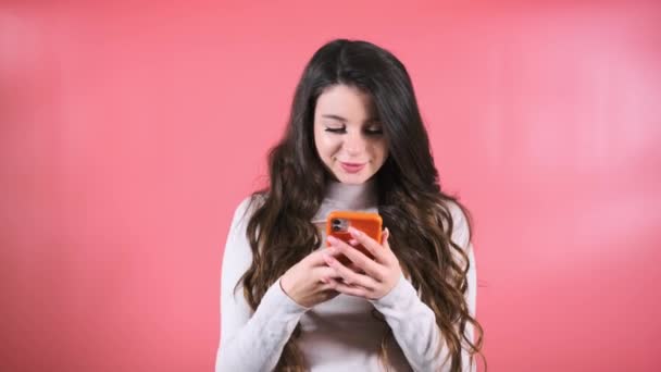 Καστανή Γυναίκα Ενθουσιασμένες Εκφράσεις Πληκτρολογεί Μηνύματα Πορτοκαλί Smartphone Lady Scrolls — Αρχείο Βίντεο