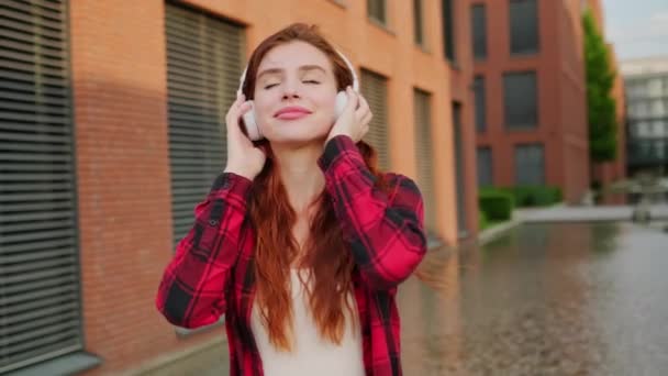 年轻的休闲学生在城市里散步时 用无线耳机听音乐 — 图库视频影像