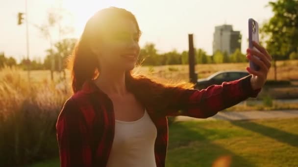 Ευτυχισμένη Νεαρή Γυναίκα Έχει Μια Βιντεοκλήση Χρησιμοποιώντας Smartphone Στο Δρόμο — Αρχείο Βίντεο