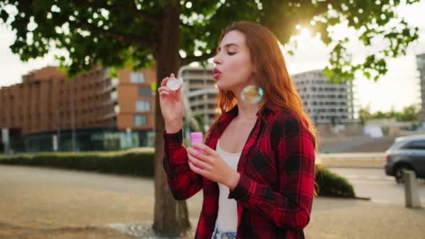 Wanita Muda Mengenakan Kemeja Kotak Kotak Trendi Meniup Gelembung Sabun — Stok Video