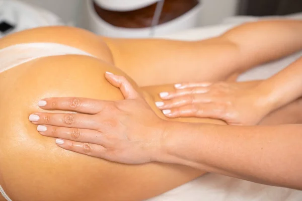 Spa massage treatment of womans buttocks and legs in a cosmetic salon. Body contouring and skin care