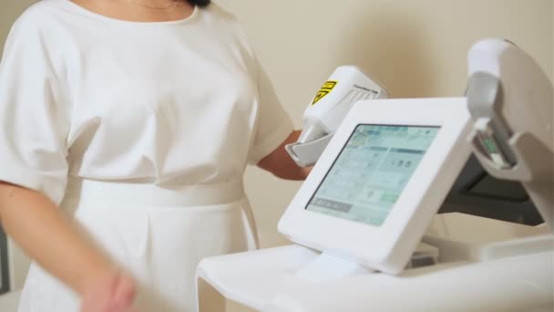 皮肤科医生站在激光消融装置上 美容师调整器件屏幕设置用于激光消融工艺 — 图库视频影像