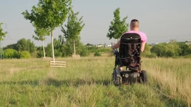Людина Інвалідному Візку Під Час Неквапливої Прогулянки Зеленому Лузі Освітленому — стокове відео