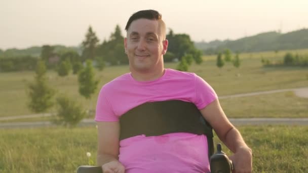 Dorosły Mężczyzna Urazem Pleców Różowej Koszulce Siedzący Wózku Inwalidzkim Cieszy — Wideo stockowe
