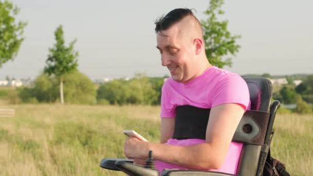 Dojrzały Mężczyzna Czarnym Wózku Inwalidzkim Trzymający Smartfona Tle Wsi Osoba — Wideo stockowe