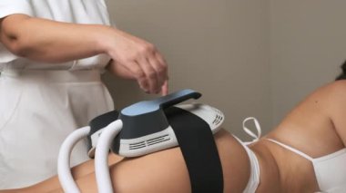 İş üniforması uzmanı bir kadın, kadın kalçasından vücut şekillendirme aleti çıkarıyor. Profesyonel atamada prosedür kavramı