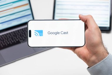 Bilgisayarın ve tabletin önündeki adamın cep telefonu ekranına uygulamanın Google döküm logosu, Aralık 2023, Prag, Çek Cumhuriyeti