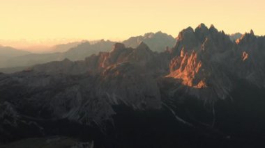 Tre Cime di Lavaredo tepeleri, İtalyan Alplerinde gün batımının sıcacık parıltısıyla yıkanır..