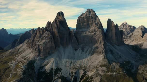 Tre Cime Lavaredo Peaks Soar Azure Sky Amidst Rugged Terrain — Stock Video