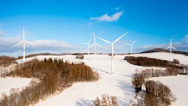 冬の晴れた日の丘の上の風力タービン農場のパノラマビュー 再生可能エネルギーの生産 ストック写真