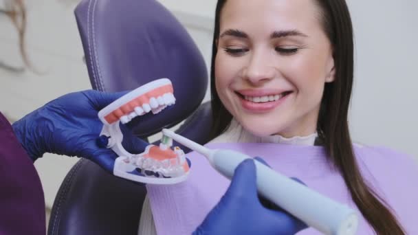 Profissional Dentário Explica Paciente Feminino Como Escovar Dentes Corretamente Clínica — Vídeo de Stock