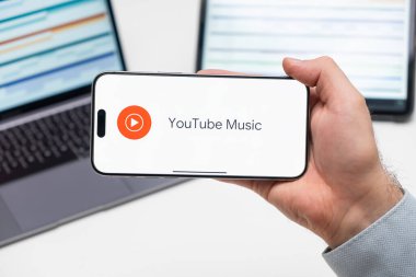 PRAG, CZECH REPUBLIC - 21 Ocak 2024: Youtube Müzik logosu iş adamlarının el ve dizüstü bilgisayarında ekranda. 