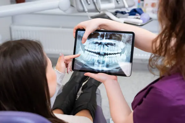 Female Dentist Discusses Treatment Strategies Patient Displaying Ray Image Tablet Stock Photo