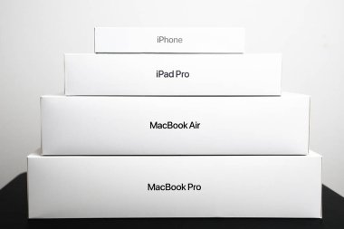 BERLİN, GERMANY - 14 HAZİRAN 2024: MacBook Pro Piramidi, MacBook Air, iPad Pro ve iPhone siyah bir masa üzerinde. 
