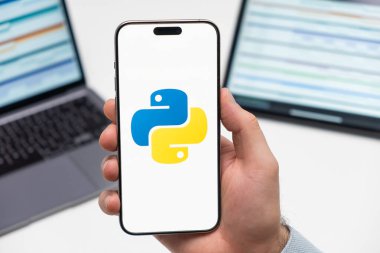 PRAGUE, CZECH REPUBLIC - 21 HAZİRAN 2024: İş arka planındaki erkek eli akıllı telefon ekranında Python logosu. 