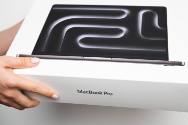 BERLİN, Almanya - 14 Şubat 2024: MacBook Pro in the women hands on the white background. 
