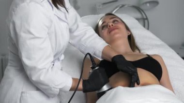 Kozmetik uzmanı, ultrason cihazı kullanarak kadınların karnında bir kaldırma işlemi uyguluyor.