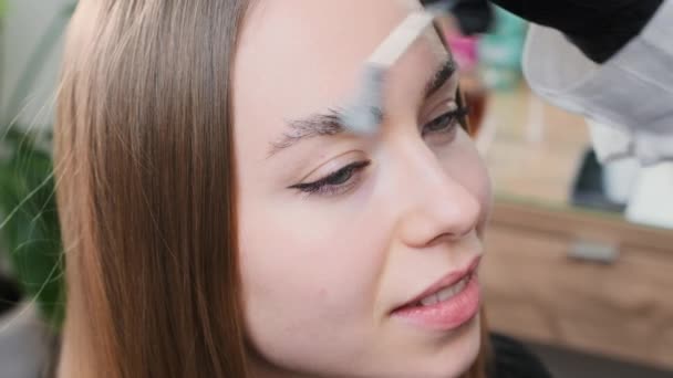 美容师用泡沫清洁剂净化眉毛 护肤专业人员确保泡沫有效去除客户眉毛上的皮肤碎片 — 图库视频影像