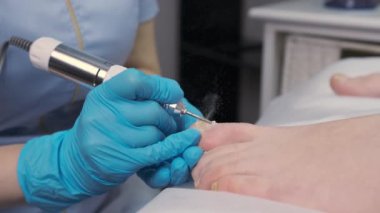 Pedikür uzmanı kuaförde ayak nalbur pedikür yapıyor.