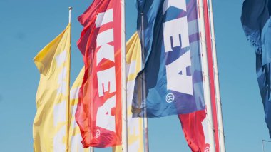 PRAG, CZECHIA - APRIL, 2024: Gökyüzüne karşı rüzgarı sallayan renkli IKEA bayrakları.