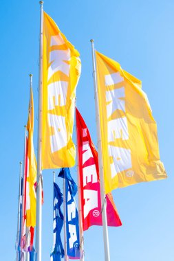 PRAG, CZECHIA -APRIL, 2024: Mavi gökyüzüne karşı farklı renkler IKEA bayrakları.