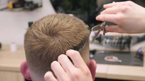 床屋は床屋のクローズアップの虚栄心ミラーによって顧客の毛を和らげることを切ります 美容師は グルーミングサロンで男性にスタイリッシュなヘアカットを行うハサミを使用しています — ストック動画