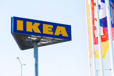 PRAG, CZECHIA -APRIL, 2024: IKEA kitle pazarı ve mavi gökyüzüne karşı bayraklar.