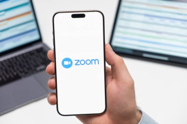 PRAG, CZECH REPUBLIC - 21 HAZİRAN 2024: İş arka planındaki akıllı telefon ekranında zoom logosu. 
