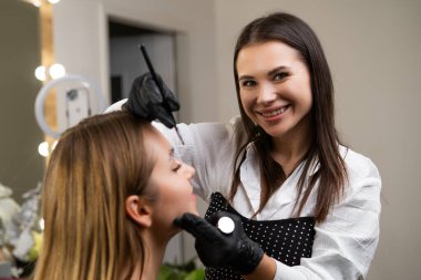 Güzellik salonundaki kaş kaplama uygulamasında güzellik hocasının portresi.