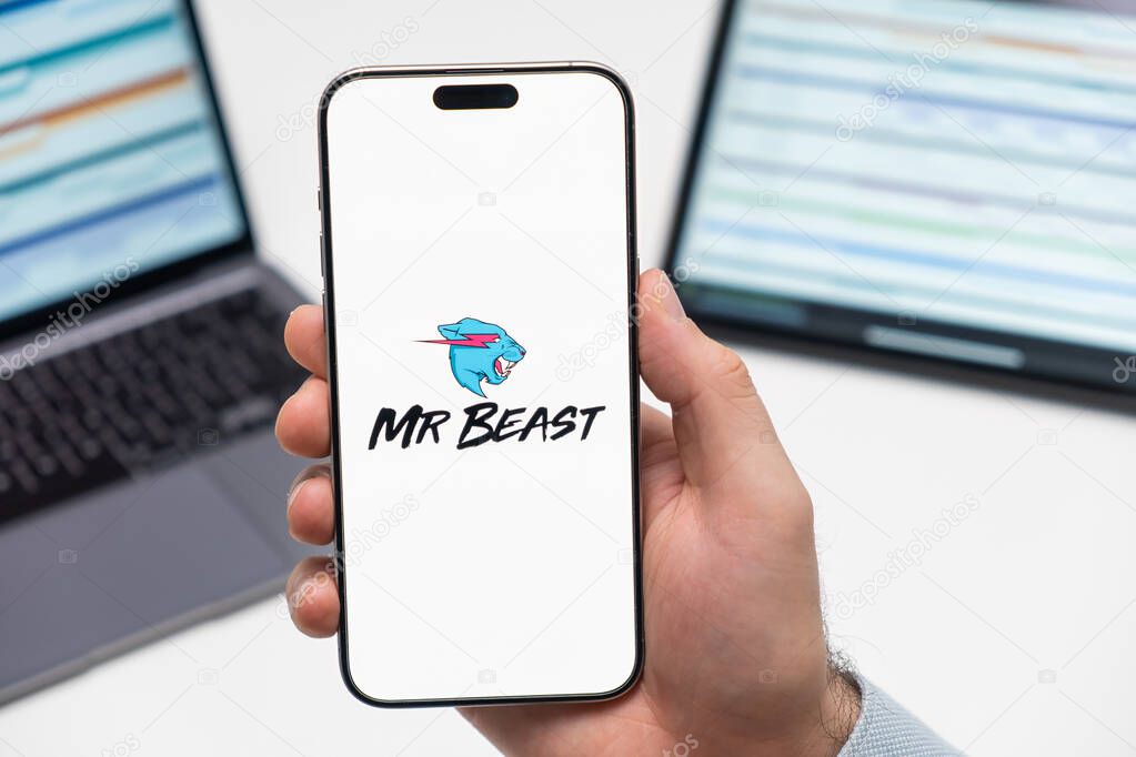 PRAGUE, CZECH REPUBLIC - JANUARY 21 2024: Mr Beast logo on the screen of smartphone in mans hand on the workplace background.