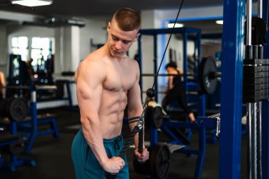 Vücut geliştirici spor salonunda kablo TV 'de çalışıyor. Trisepslerin eğitimi