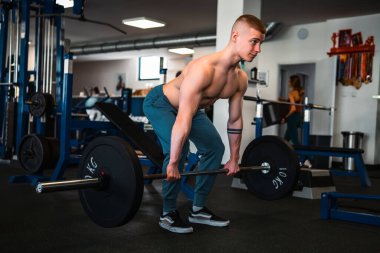 A bodybuilder performs a deadlift exercise in a gym setting clipart