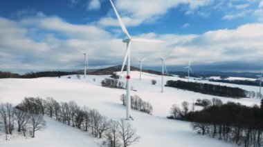 PRAG, CZECHIA - Şubat 2024: Bir kış tarlası yenilenebilir enerji üretimi için merkezi bir merkez olarak hizmet veren bir rüzgar türbini parkına ev sahipliği yapıyor. 