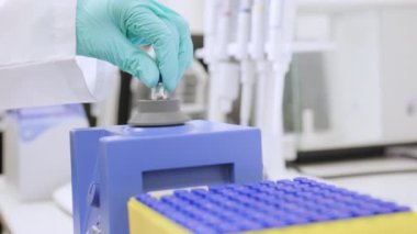 HPLC analizinden önce girdap karıştırıcı kullanarak numune sallayan bir kadının fotoğrafını çek.