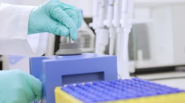 Laboratuvarda HPLC analizi yapılmadan önce bir kimyagerin girdap karıştırıcı kullanarak numuneleri sallamasını kapatın. 