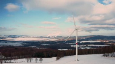 PRAG, CZECHIA - Şubat 2024: Karlı bir alanın ortasında, bir rüzgar türbini parkı yenilenebilir enerji üretimi için anahtar bir merkez görevi görüyor.