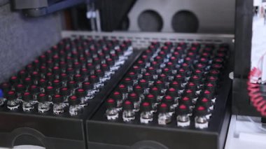 Siyah başlıklı cam şişelerdeki örnekler HPLC sistemindeki otomatik örnekleyicide analiz için bekliyor