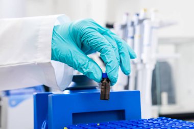 Bir kimyager HPLC analizinden önce örnekleri sallamak için girdap karıştırıcı kullanır