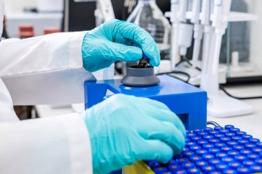Laboratuvarda HPLC analizi yapılmadan önce bir kimyagerin girdap karıştırıcı kullanarak numuneleri sallamasını kapatın. 