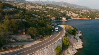 Yol boyunca karavanda teknesi olan turist minibüsü. Aile tatile dağ eteğinde otomobil güzergahına gider.
