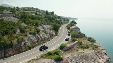 Çatıda SUP olan araba, gök mavisi deniz ve yeşil yamaçlı kayalık yamaçlar boyunca yol alır. Otomobille eğlenceli bir gezi doğanın çarpıcı manzarasını sunuyor.