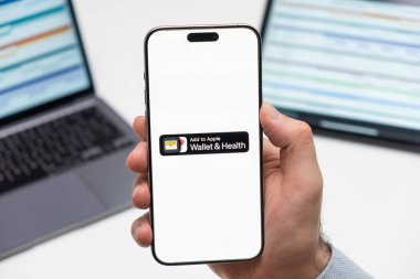 PRAG, CZECHIA - Temmuz 2024: Cüzdan ve Sağlık logosu arka planda erkek eli ve dizüstü bilgisayarda akıllı telefon ekranında 