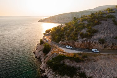 Manzaralı kıyı yolu, gün batımında güzel dağlık bir bölgede sahil boyunca ilerliyor.. 